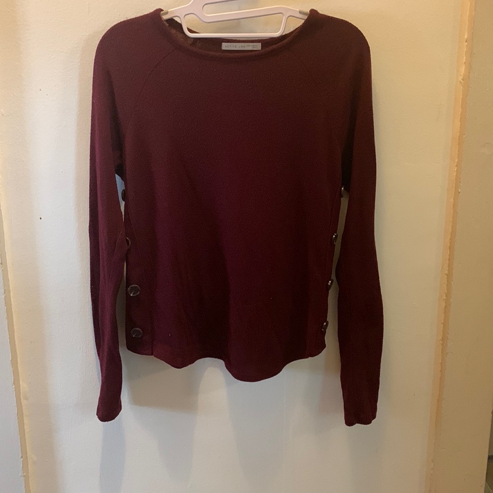 Long sleeve, maroon top. Buttons down the sides, full coverage.